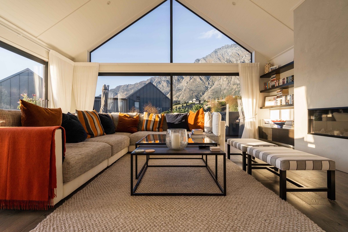 Neil & Fleur enjoy sitting in their luxury living area, with warm terracotta and navy tones, featuring a long gas fireplace to keep the home warm inside even while it is cold outside.